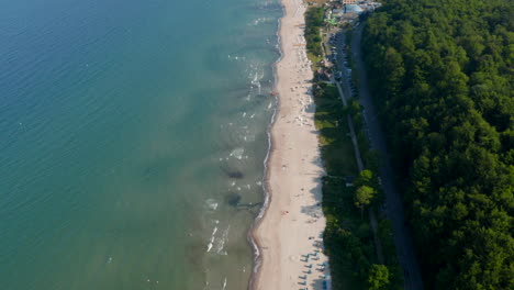 Amazing-aerial-drone-flying-above-tourist-Baltic-sea-beach-in-Scharbeutz,-Germany,-dolly-in,-day